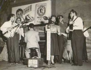 Blackie (far left) chats with guitar legend Chester "Chet" Atkins over his shoulder on stage at the Grand Ole Opry.